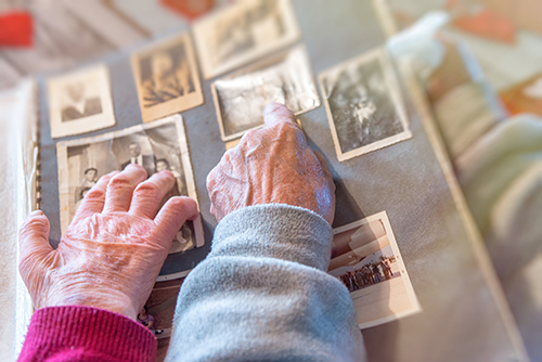 Older couple looking though a photo album cherishing the memories of their loved ones and friends
